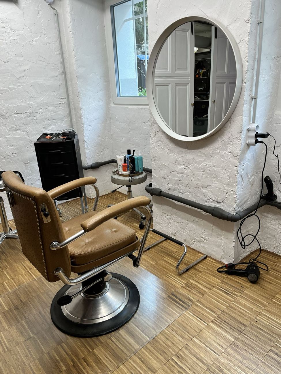 Alter Friseurstuhl vor rundem Spiegel